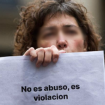 Una mujer muestra un cartel de "No es abuso es violación"
